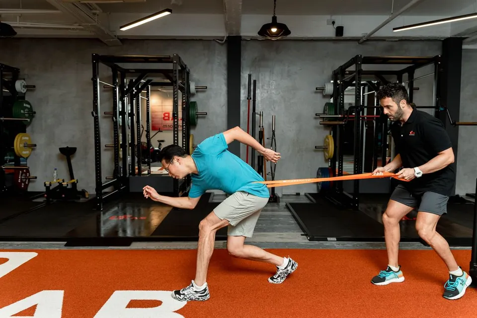 Personal trainer guiding an athlete through resistance training
