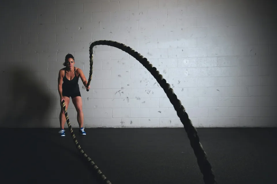An athlete putting in focused effort with battle ropes